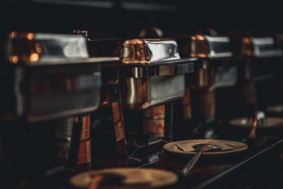 Reihe von glänzenden Espressomaschinen in dunkler Umgebung.